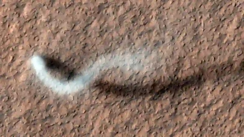 Toz Şeytanı Mars'ta Kükrüyor NASA'nın Mars Keşif Yörünge Aracı'ndaki Yüksek Çözünürlüklü Görüntüleme Bilim Deneyi (HiRISE) kamerası tarafından elde edilen bu görüntüde (Nisan 2012), yükselen bir toz şeytanı Mars yüzeyi üzerinde yılan gibi bir gölge oluşturuyor. NASA/JPL-Caltech/ Arizona Üniversitesi
