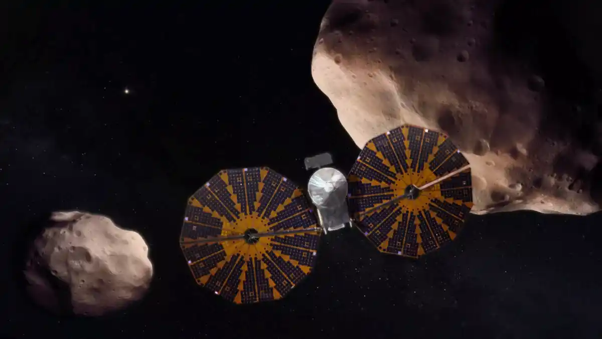 An artist's depiction of the Lucy spacecraft flying past a pair of Trojan asteroids. (Image credit: NASA's Goddard Space Flight Center)